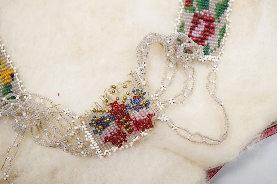 A glass bead necklace, early 19th century, intricately composed of woven glass beads depicting panels of butterflies and flowers, together with early 20th century correspondence from the Victorian & Albert Museum discuss